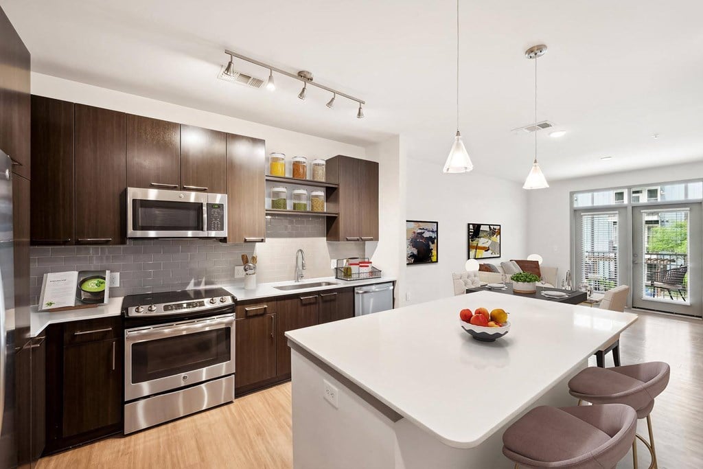 a kitchen with a large island and a white counter top at Glenwood at Grant Park Apartments, Atlanta